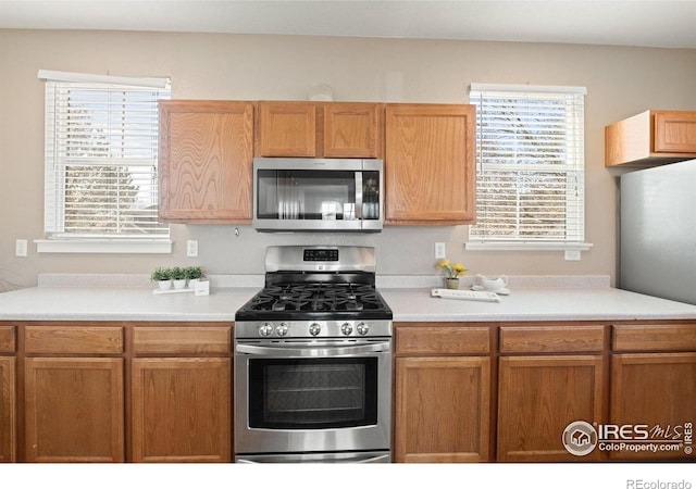 658 Casper Dr, Lafayette, CO 80026 - kitchen with stainless steel appliances, light countertops, and brown cabinetry
