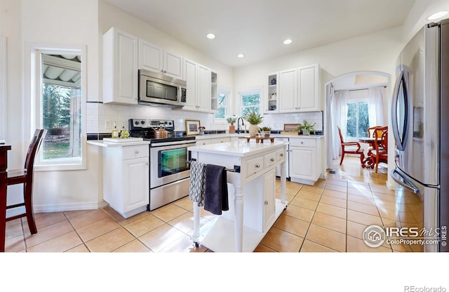 5105 Nelson Ct, Fort Collins, CO 80528 - kitchen with white cabinets, a sink, light countertops, stainless steel appliances, and decorative backsplash