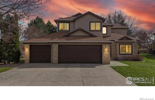 5105 Nelson Ct, Fort Collins, CO 80528 - traditional-style house with stucco siding, driveway, brick siding, a shingled roof, and a lawn