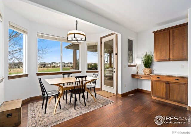 7225 Royal Country Down Dr, Windsor, CO 80550 - dining space featuring dark wood-style flooring and baseboards
