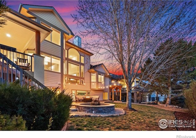 7225 Royal Country Down Dr, Windsor, CO 80550 - rear view of house with an outdoor fire pit, a balcony, and a patio area