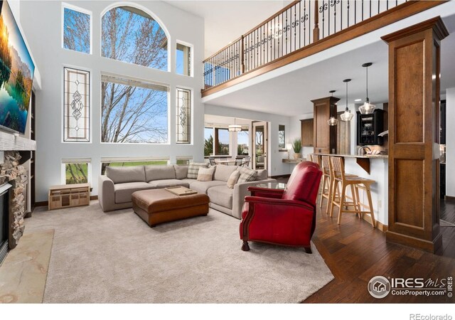 7225 Royal Country Down Dr, Windsor, CO 80550 - living room with a high ceiling, a stone fireplace, and wood finished floors