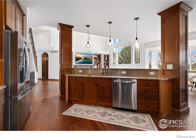 7225 Royal Country Down Dr, Windsor, CO 80550 - kitchen with appliances with stainless steel finishes, a sink, brown cabinets, and dark wood finished floors