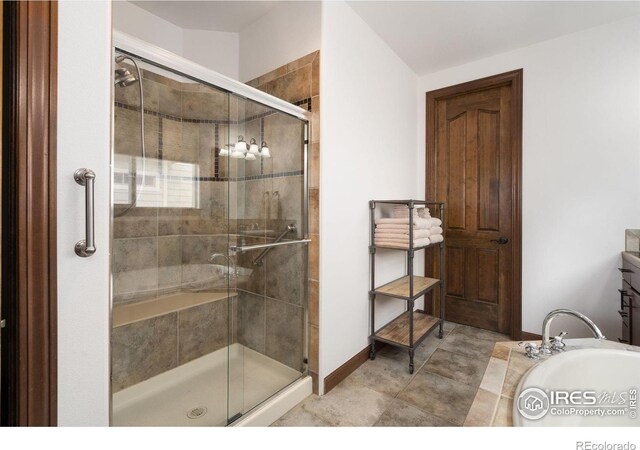 7225 Royal Country Down Dr, Windsor, CO 80550 - bathroom featuring a stall shower, a bathtub, and baseboards