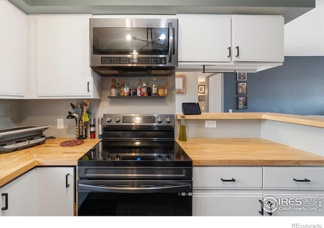 2660 E Otero Pl Unit 7, Centennial, CO 80122 - kitchen featuring black electric range oven, stainless steel microwave, wood counters, and white cabinets