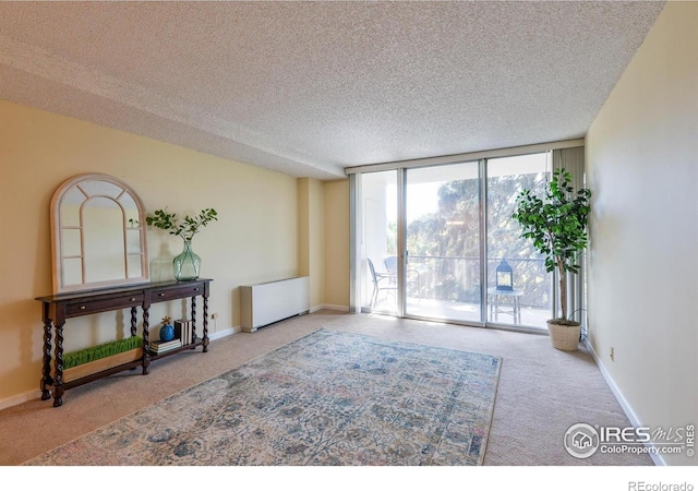 interior space with radiator, carpet, a textured ceiling, floor to ceiling windows, and baseboards
