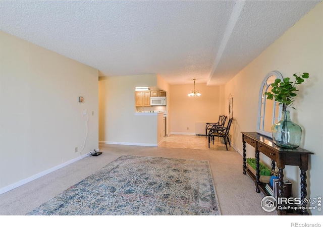 interior space featuring baseboards, light colored carpet, a textured ceiling, and an inviting chandelier