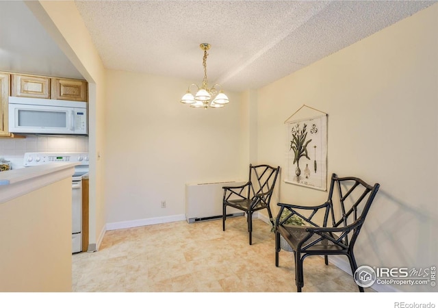 interior space with a textured ceiling, an inviting chandelier, and baseboards