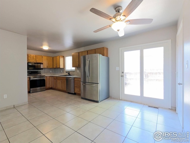 kitchen with visible vents, a sink, light countertops, appliances with stainless steel finishes, and brown cabinets