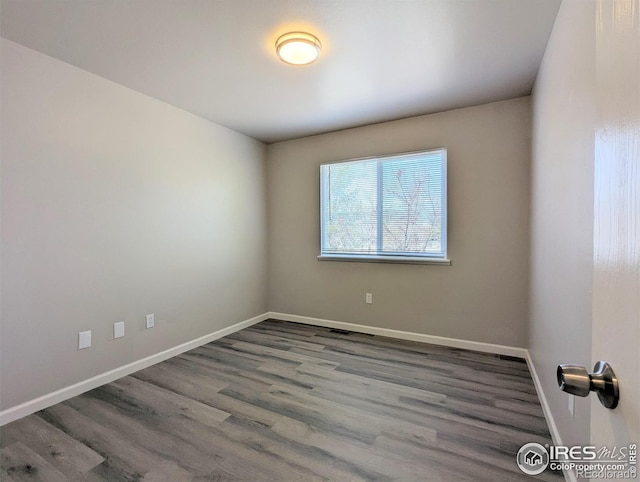 unfurnished room featuring baseboards and wood finished floors