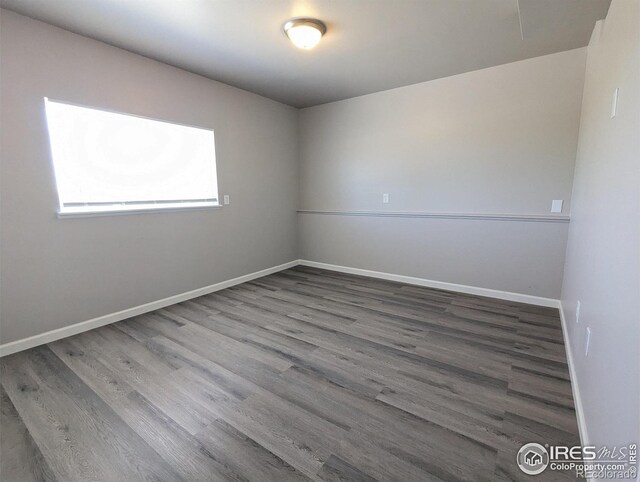 unfurnished room featuring baseboards and wood finished floors