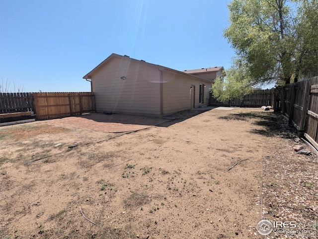 rear view of property featuring a fenced backyard
