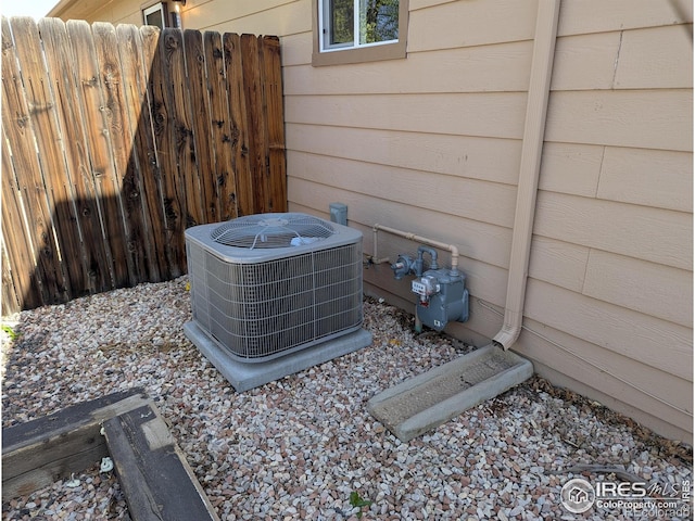 details featuring gas meter, fence, and central AC