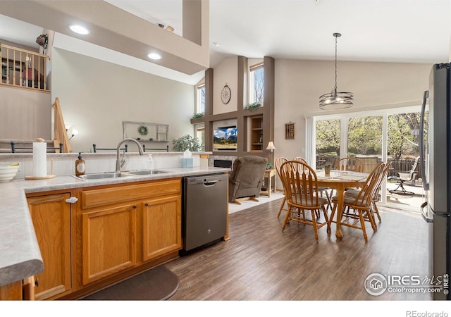 461 Scenic Dr, Loveland, CO 80537 - kitchen with appliances with stainless steel finishes, wood finished floors, a sink, high vaulted ceiling, and light countertops