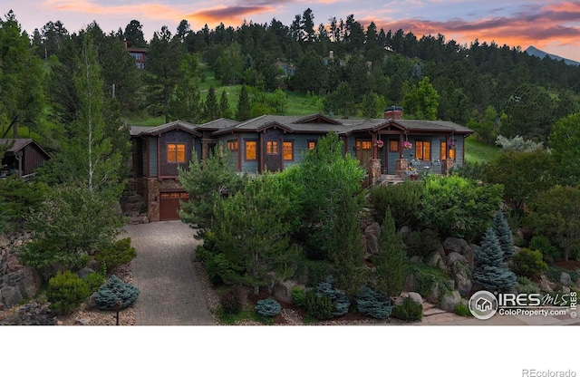 1420 Sierra Dr, Boulder, CO 80302 - view of front of house with a garage, decorative driveway, and a wooded view