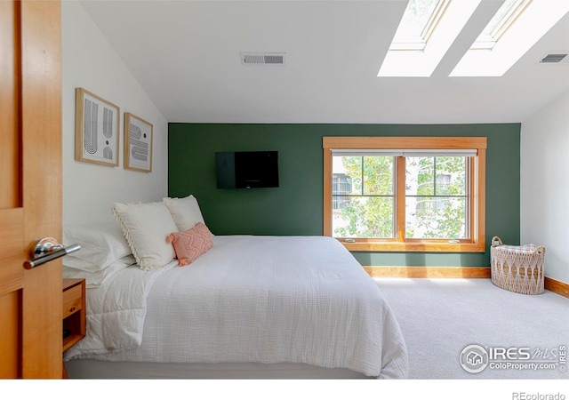 bedroom featuring baseboards, carpet flooring, lofted ceiling with skylight, and visible vents