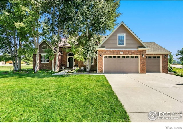 4939 Yoke Ct, Loveland, CO 80537 - view of front facade featuring driveway, a front lawn, brick siding, and a garage
