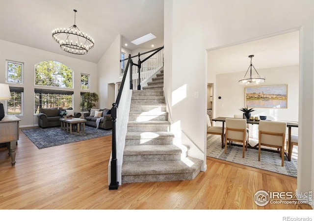 4939 Yoke Ct, Loveland, CO 80537 - stairs with a chandelier, a high ceiling, and wood finished floors