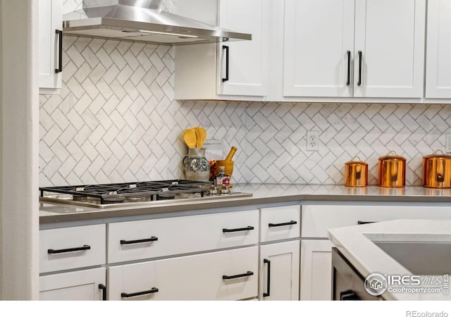 4939 Yoke Ct, Loveland, CO 80537 - kitchen with wall chimney exhaust hood, stainless steel gas stovetop, white cabinets, and tasteful backsplash