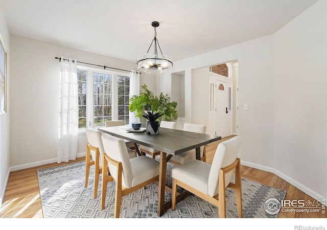 4939 Yoke Ct, Loveland, CO 80537 - dining area with a chandelier, light wood-style floors, and baseboards