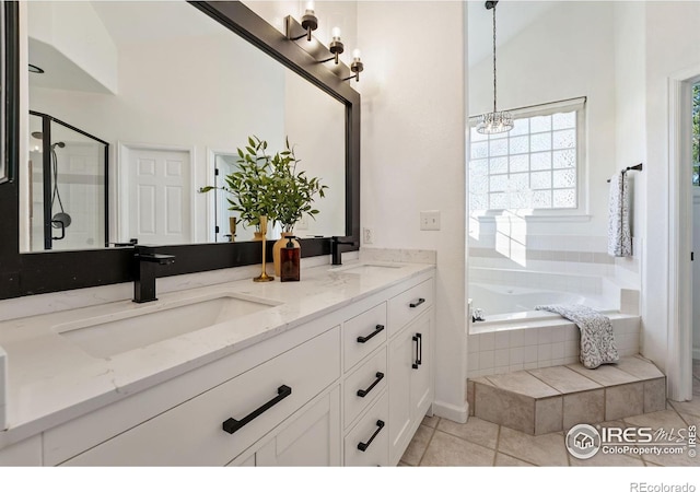 4939 Yoke Ct, Loveland, CO 80537 - bathroom with a garden tub, double vanity, a chandelier, a shower stall, and tile patterned floors