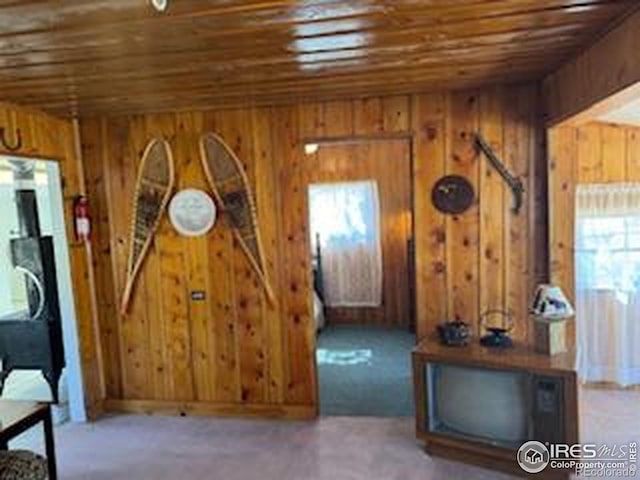 interior space featuring wood ceiling and wood walls