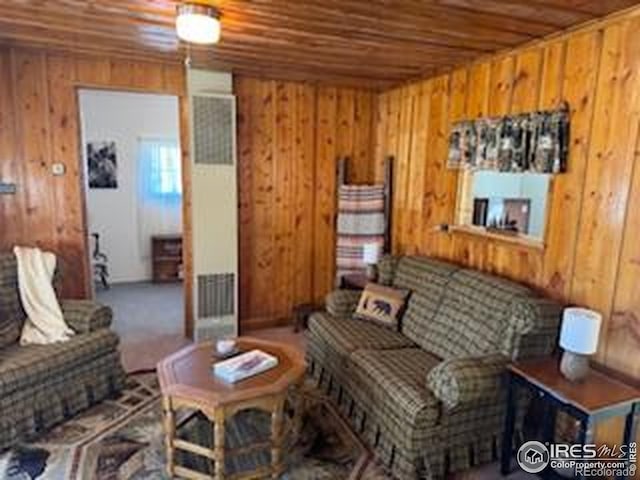 living room featuring wooden walls, visible vents, and wood ceiling