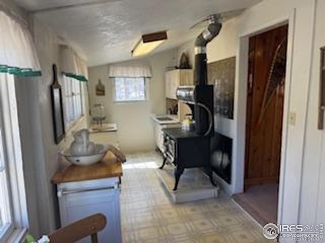 kitchen with a wood stove and vaulted ceiling