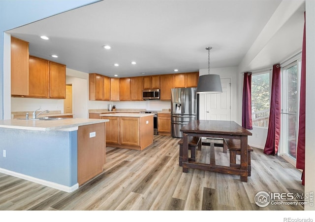 kitchen featuring a sink, light countertops, appliances with stainless steel finishes, light wood-style floors, and recessed lighting