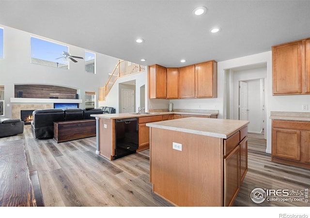 kitchen featuring light wood finished floors, light countertops, black dishwasher, and ceiling fan