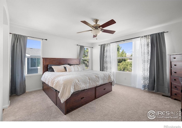 carpeted bedroom featuring baseboards and a ceiling fan