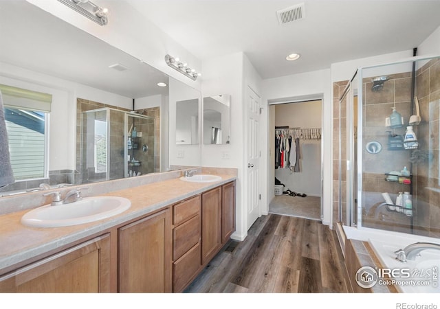 full bathroom featuring a shower stall, double vanity, visible vents, and a sink