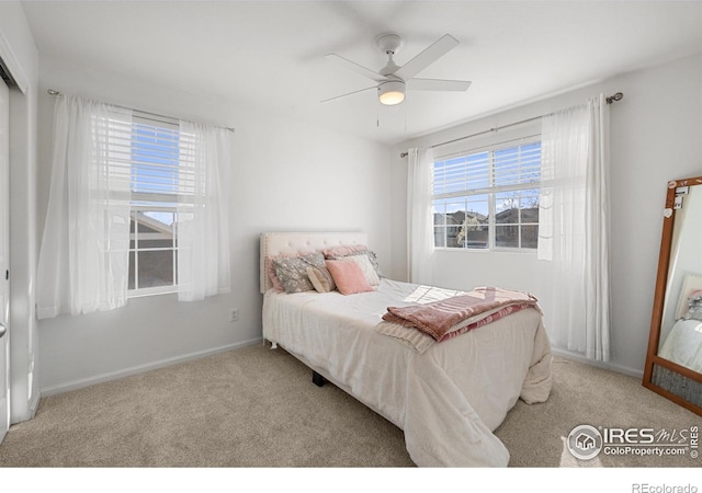 carpeted bedroom featuring baseboards and a ceiling fan