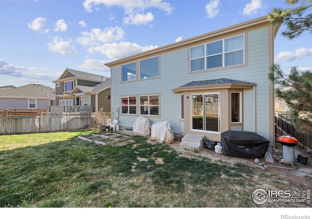 rear view of house featuring a yard and fence
