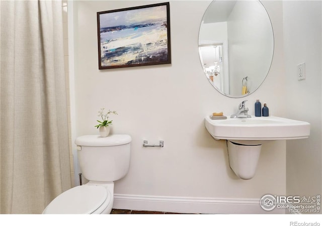 bathroom featuring toilet, a shower with shower curtain, tile patterned flooring, and baseboards