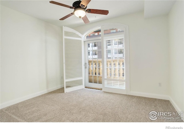 carpeted empty room featuring baseboards and ceiling fan