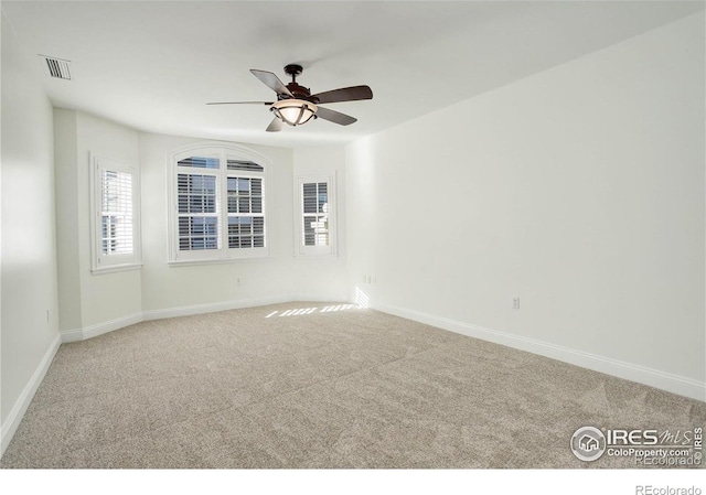 unfurnished room featuring carpet floors, baseboards, and a wealth of natural light