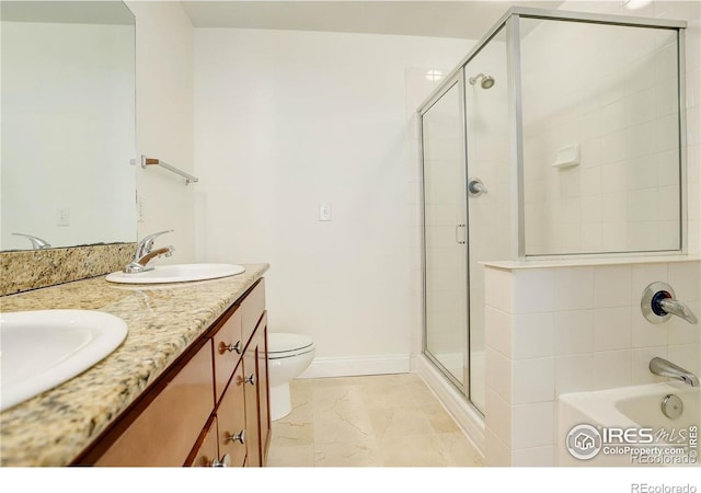 full bathroom featuring double vanity, baseboards, a sink, and a stall shower