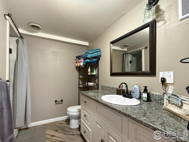 full bathroom with curtained shower, wood finished floors, visible vents, toilet, and vanity