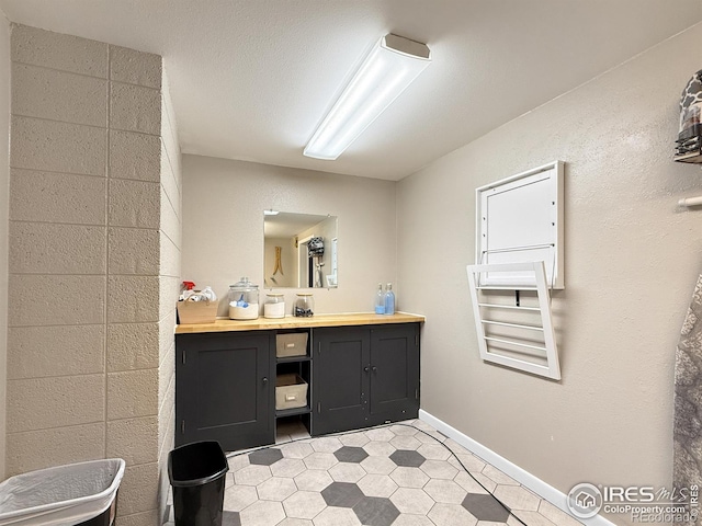 bathroom with baseboards, tile patterned floors, and vanity