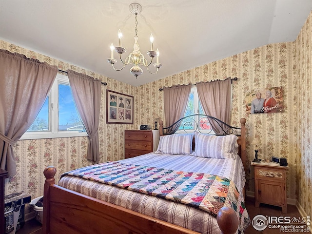 bedroom with an inviting chandelier, wallpapered walls, and baseboards