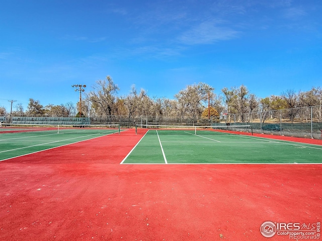 view of tennis court featuring fence