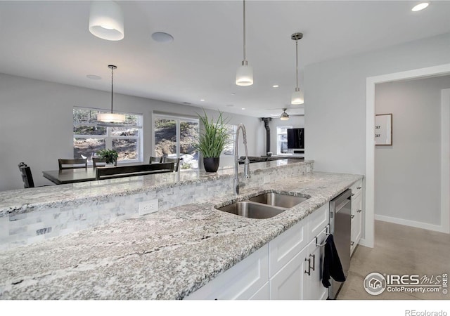 609 Hummer Dr, Nederland, CO 80466 - kitchen featuring decorative light fixtures, a sink, white cabinetry, stainless steel dishwasher, and light stone counters