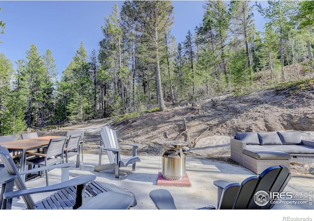 609 Hummer Dr, Nederland, CO 80466 - view of patio featuring an outdoor hangout area, outdoor dining area, and a forest view