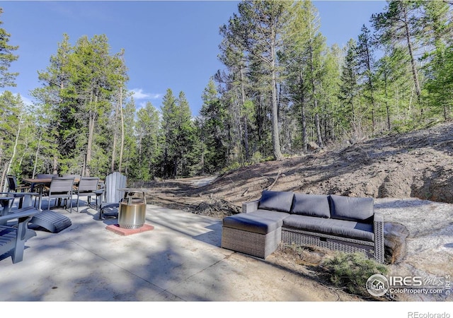 609 Hummer Dr, Nederland, CO 80466 - view of patio with outdoor dining space, an outdoor living space, and a view of trees