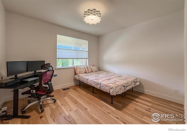 bedroom featuring light wood-type flooring, a desk, and baseboards