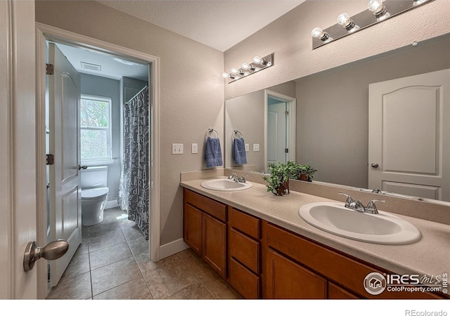 full bathroom with toilet, double vanity, tile patterned floors, and baseboards