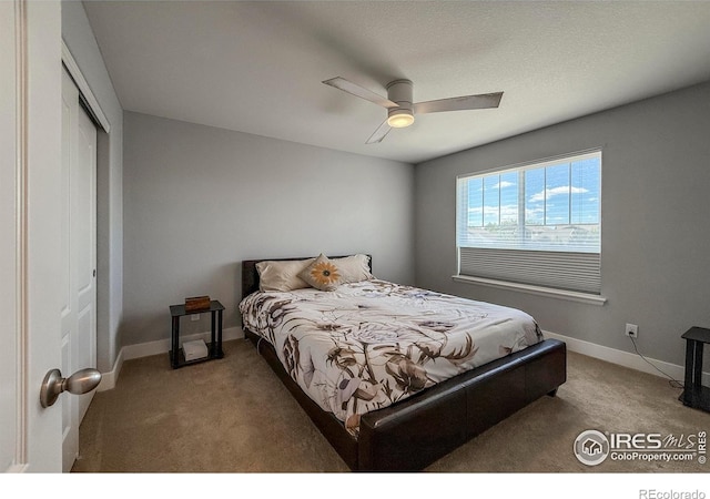 bedroom with carpet, a closet, baseboards, and a ceiling fan