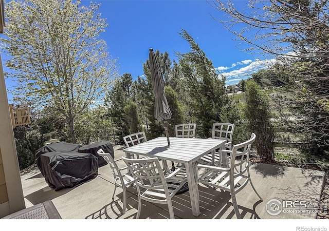 wooden terrace with outdoor dining area and a patio
