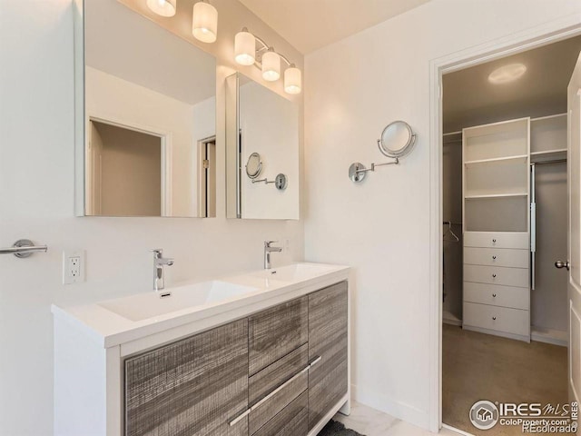 full bath with double vanity and a spacious closet